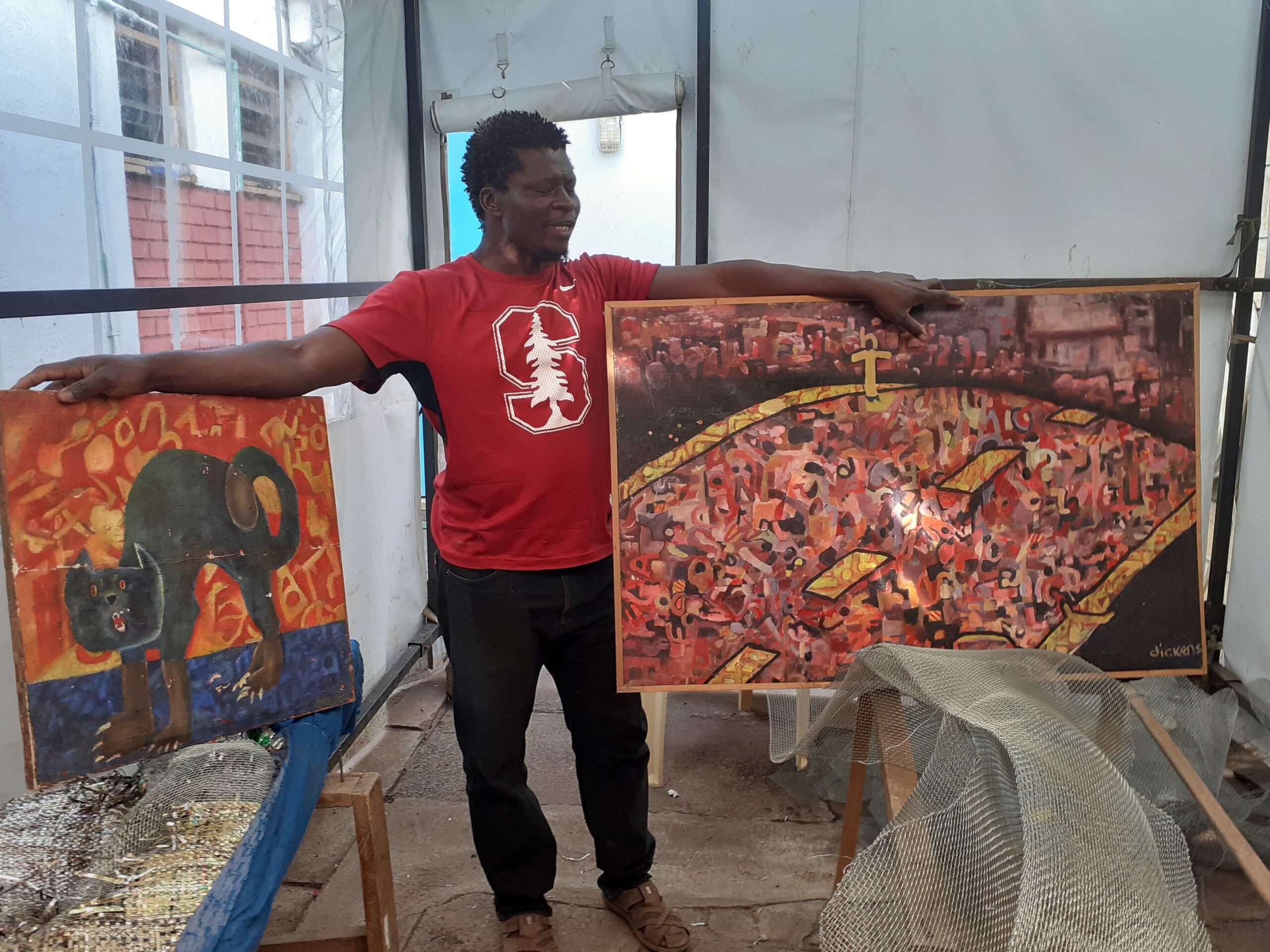 Otieno with some of the early canvases he painted before turning his artistic attention to woven sculpture.